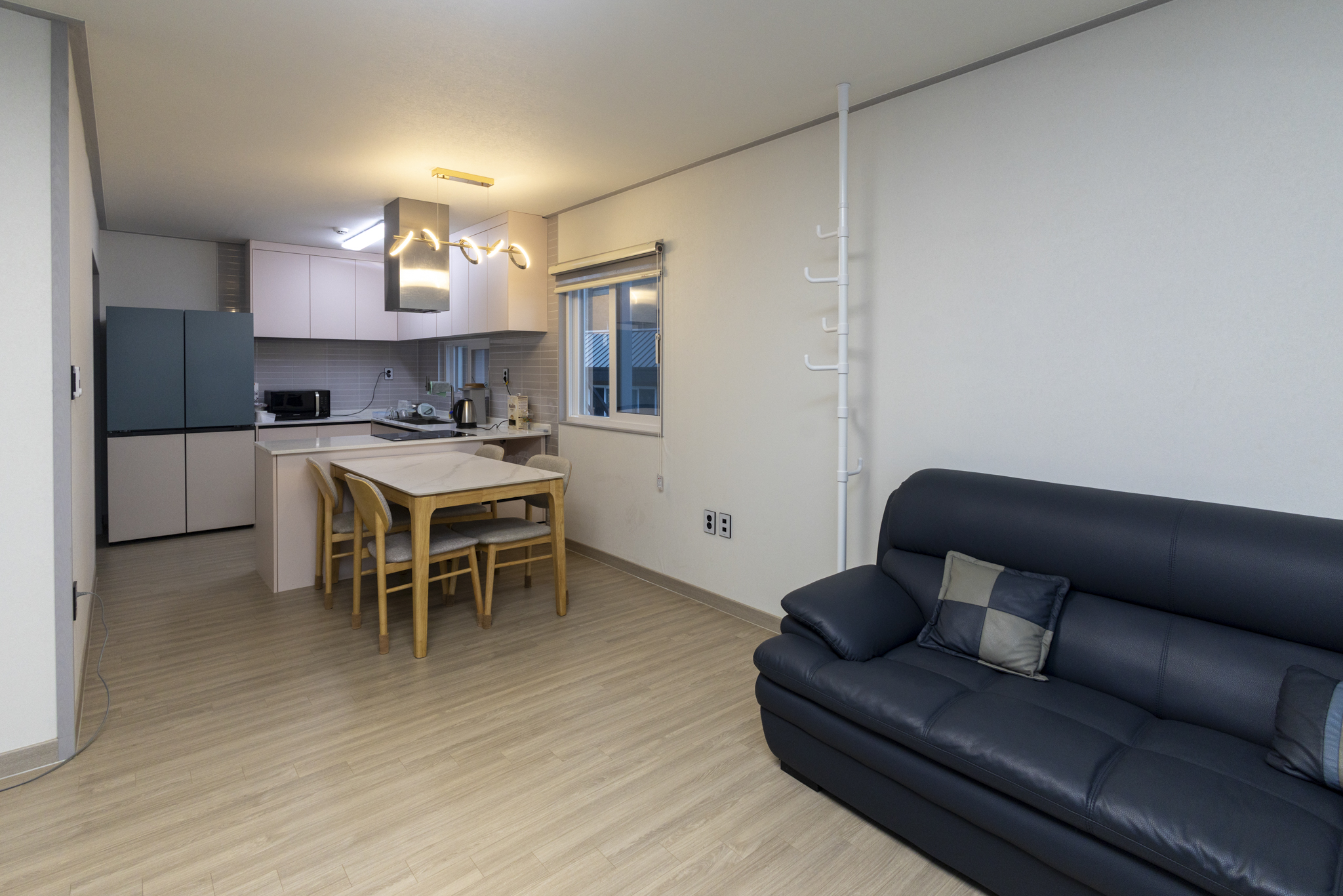 1층 주방과 식탁, 거실이 이어지는 오픈 레이아웃 공간.