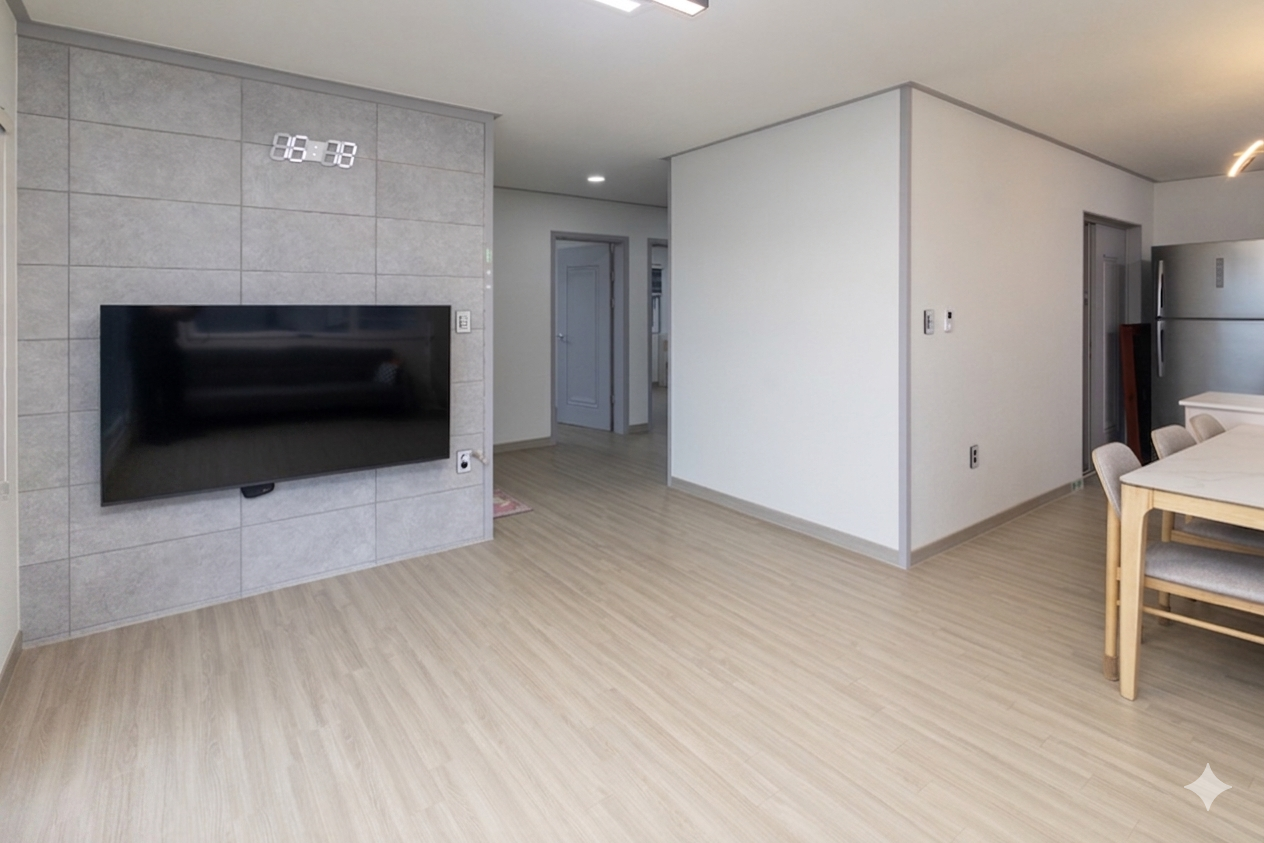 2층 거실 내부. 우드 바닥과 TV가 있는 모던한 공간.